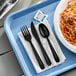 A tray with a bowl of spaghetti and black utensils including a fork and knife on a white napkin.