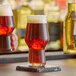 A close up of a Rastal Craft Master One beer glass on a coaster full of beer.