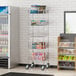 A Regency chrome cart with shelves holding beverages in a convenience store.