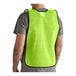 A person wearing a lime high visibility mesh safety vest.