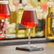 Two Rastal Teku mini beer glasses on a bar counter.