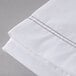 A white Oxford T250 Superblend flat sheet with brown stitching.