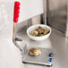 A Vollrath Oyster King stainless steel oyster shucker on a metal cutting board with oysters.
