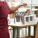 A man holding a metal rack with utensils.