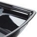 A black plastic Cambro Camwear rectangular ribbed bowl with curved edges.