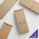 A white background with several brown Choice kraft paper bags with blue, green, orange, and pink custom text.