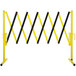 A yellow and black Versare portable safety gate with wheels.