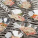 Outset stainless steel oyster grill shells on a grill with food.
