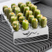 A tray of jalapeno peppers roasting on an Outset stainless steel rack over a grill.