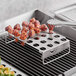 Stainless steel grill tray with food on it.