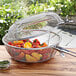 An Outset stainless steel grill basket filled with peppers and herbs.