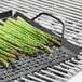 An Outset non-stick grill tray with asparagus cooking on it.