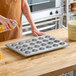 A 24-cup glazed aluminized steel mini muffin or cupcake pan measuring 13 by 18 inches.
