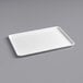 A white rectangular Baker's Mark bun tray on a gray surface.