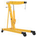 A yellow Vestil hydraulic telescoping crane with wheels.