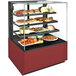 A Structural Concepts refrigerated bakery display case with food on it.