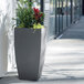 A large rectangular grey Mayne Kobi planter with plants inside.