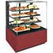 A Structural Concepts refrigerated bakery display case with food on it.
