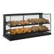 A Structural Concepts countertop bakery display with bread and doughnuts behind glass.