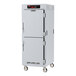 A white metal Metro C5 holding cabinet with stainless steel Dutch doors and wheels.