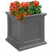 A Mayne Fairfield graphite grey planter with orange flowers in it.