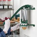 A wall-mounted potato wedge cutter being used to slice a potato into wedges.