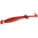 A red plastic Urnex espresso machine brush with a white tip.