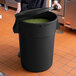 a black trash can with green beans inside