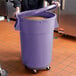 A person holding a large purple Mobile Ingredient Storage Bin with a lid.