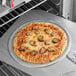 A pizza on a Choice aluminum pizza screen in an oven.