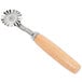 An Ateco pastry cutter with a fluted circular metal wheel and a wooden handle.