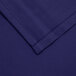 A folded navy blue square table cover with a hemmed edge.