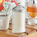 A Tablecraft beehive sugar pourer on a white table with black lines.