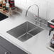 A close-up of a Regency stainless steel fabricated undermount sink bowl.