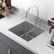 A close-up of a Regency stainless steel fabricated undermount sink bowl.