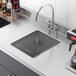 A close-up of a Regency stainless steel fabricated undermount sink bowl.