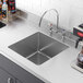 A close-up of a Regency stainless steel fabricated undermount sink bowl.