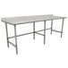 A stainless steel Advance Tabco work table with an open base and a metal bar.