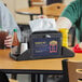 A Choice tabletop napkin dispenser with a napkin and condiments on a table.