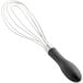 An OXO Good Grips whisk with a black handle.