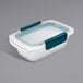 A white rectangular plastic OXO food storage container with a blue snap-on lid.