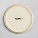 An Acopa Pangea white matte porcelain coupe plate with the word Acopa in black.