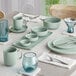 A table set with blue plates and Acopa Harbor Blue ramekins on a table in a brunch café.