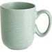 A close-up of a green Acopa Pangea porcelain cup with a handle.