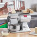 A woman using the Estella electric hard cheese grater to grate cheese.