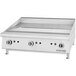 A white rectangular countertop griddle with manual controls.