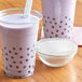 a two cups of bubble tea with a straw and a bowl of powder