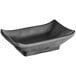 A black rectangular Acopa Izumi melamine sauce dish with a curved edge.