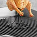 A chicken on a Fox Run chicken roaster on a grill.