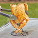 A chicken on a Fox Run carbon steel roaster rack over a grill.